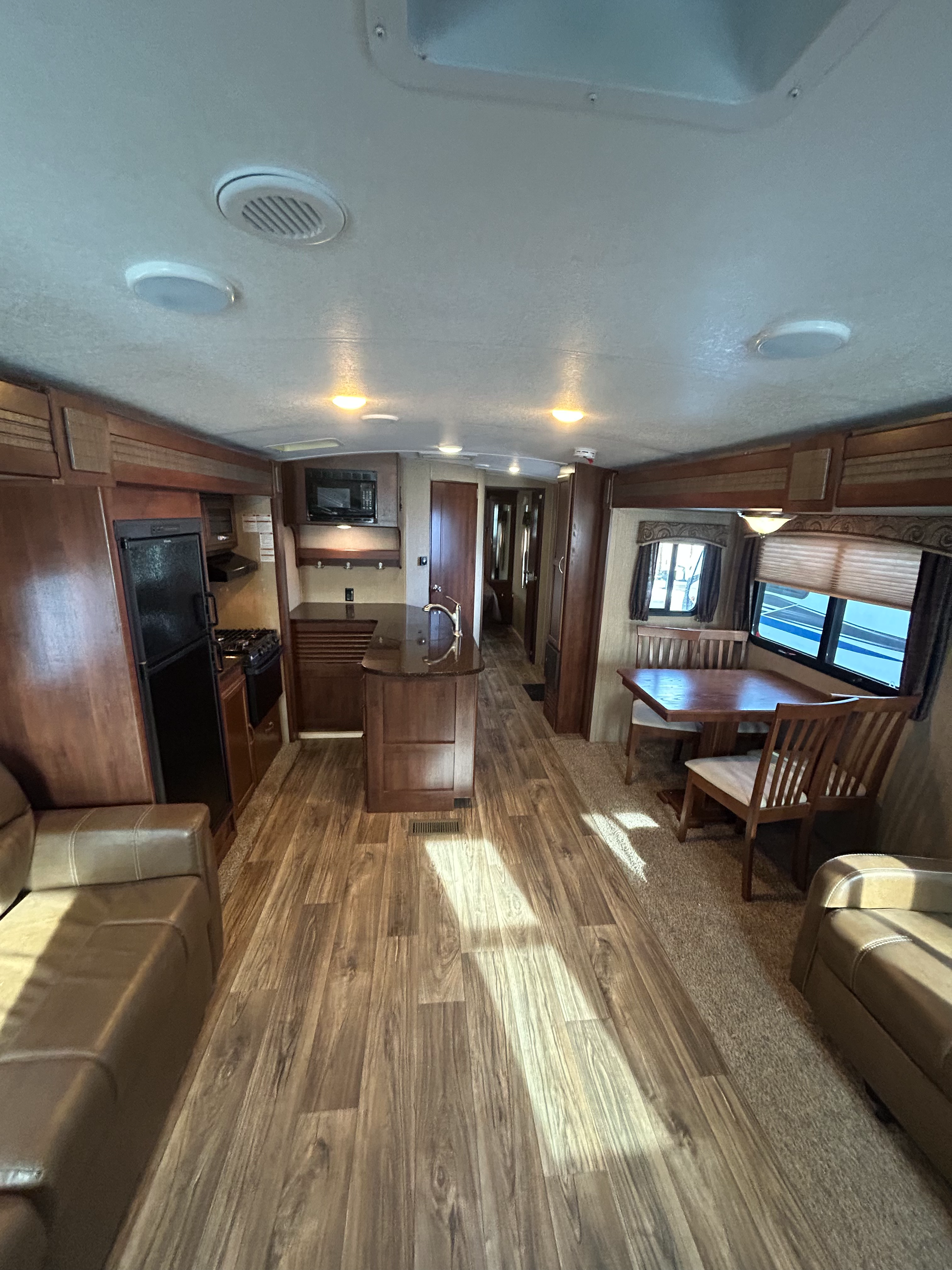 2015 Keystone Passport Elite 31RE travel trailer showing living space kitchen living-room sofas and dining area