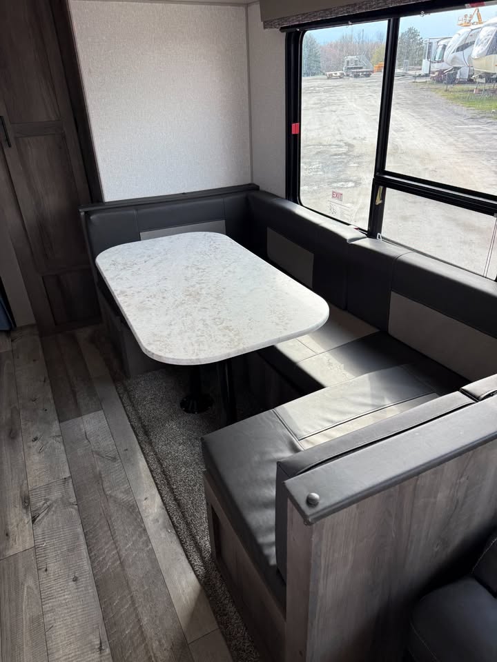 Interior of a vehicle with a fold-out table and seating area.