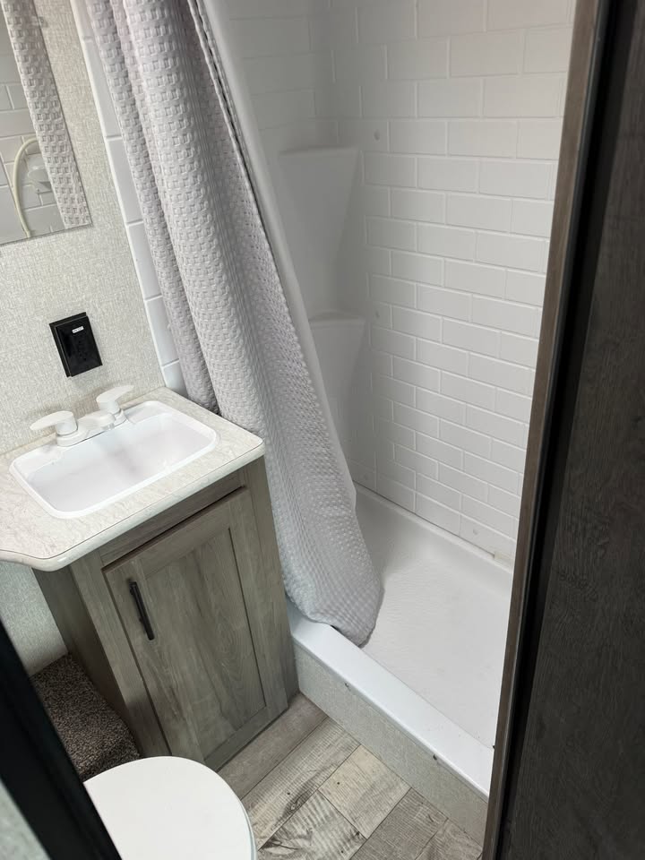 Bathroom with a walk-in shower, sink, and toilet.