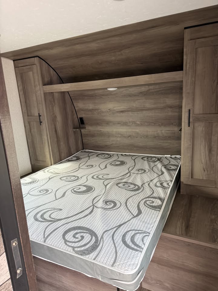 Wooden cabinetry, queen bed in bedroom