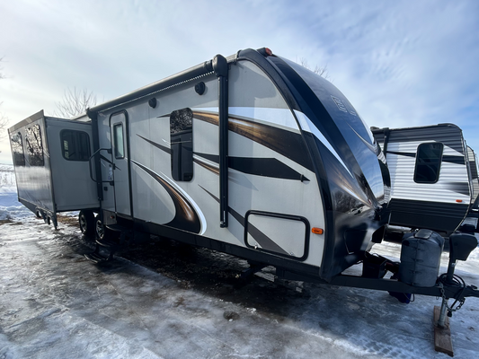 2015 Keystone Passport Elite 31RE travel trailer showing entry door and slide out